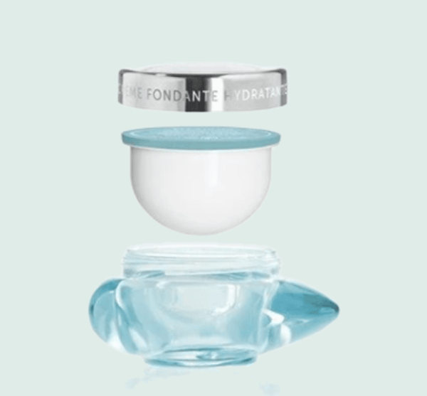 Pot de crème déstructuré, pot en verre bleue, recharde de crème en plastique blanc, couvercle métallique, sur fond verre